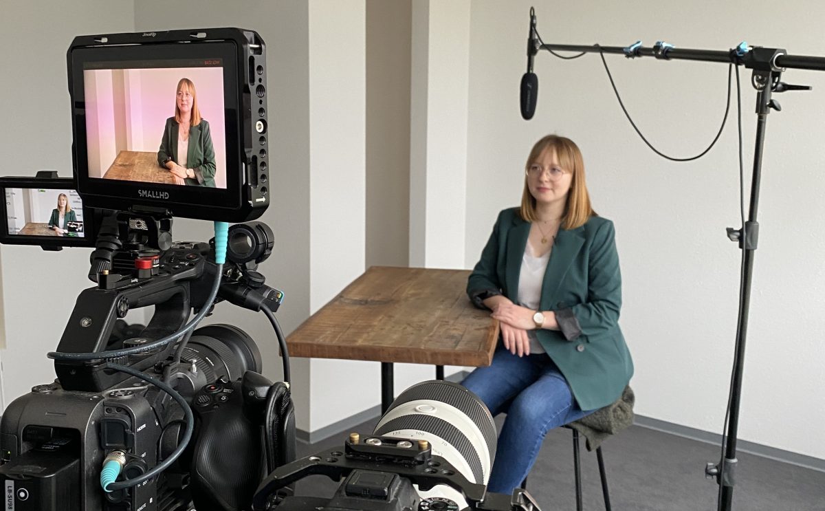 Account manager Anna-Lena Haller sits at a table. There is a camera in front of her. An interview is currently being recorded.