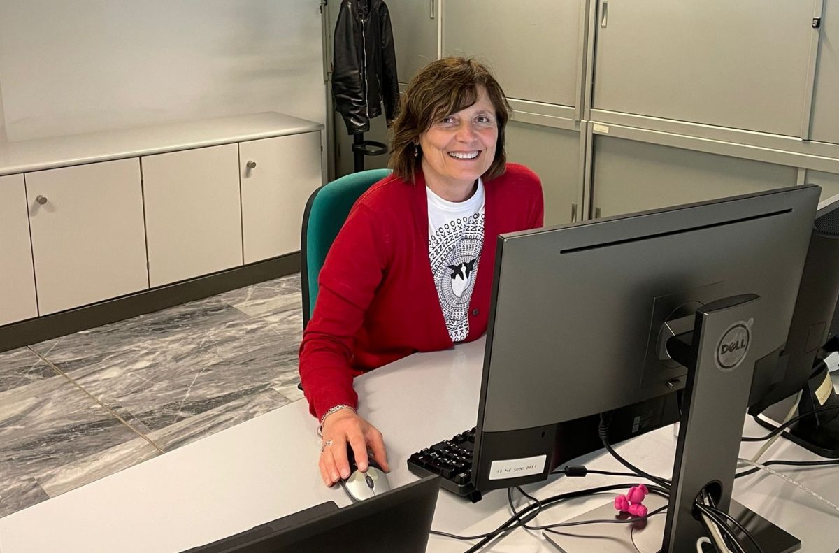Marta Bariselli sits at her desk, smiling behind her screen.