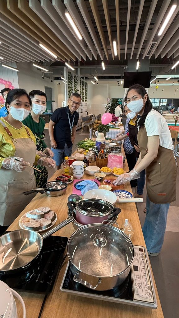 Team photo during the cooking competition: The team stands at their cooking station and smiles at the camera.