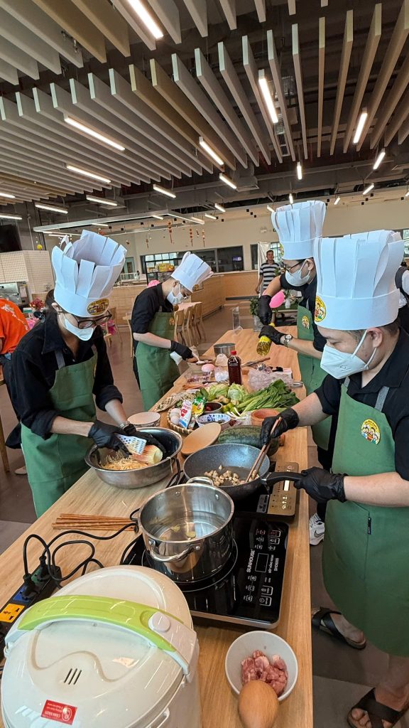Insight into the cooking competition: The team is cooking at their station.